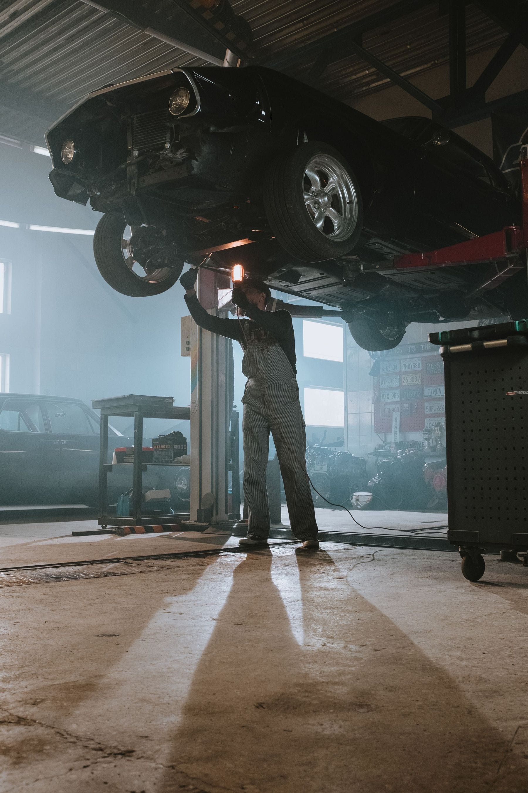A mechanic working under a car on a lift